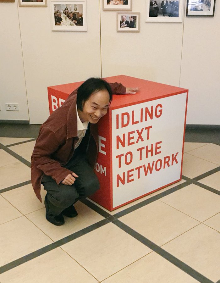 A man crouches next to a box